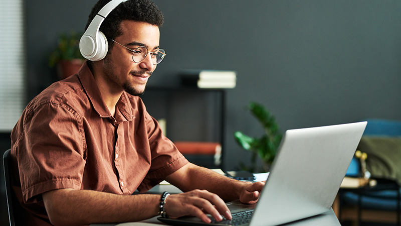 Man with headphones working in front of laptop