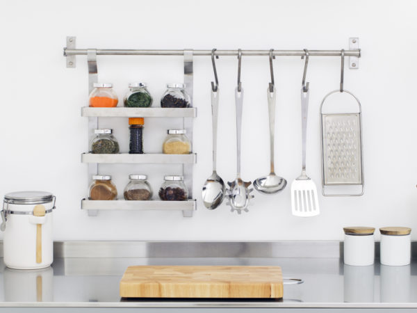 Kitchen utensils and spices in bowls in stainless steel kitchen