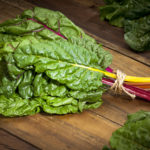 Organic Rainbow Swiss Chard Bunch on Wood Table