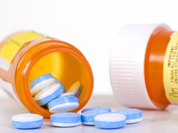 An open bottle of medicine on a table.