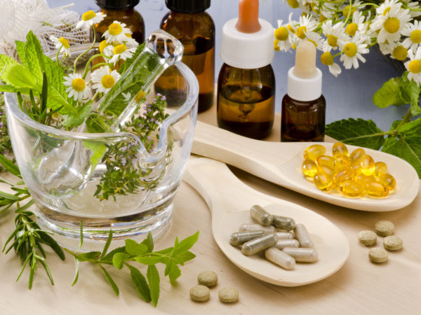 Alternative Medicine. Rosemary, mint, chamomile, thyme in a glass mortar. Essential oils and herbal supplements.