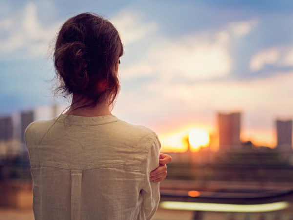 Young girl is watching sunset over Tokyo in Odaiba.