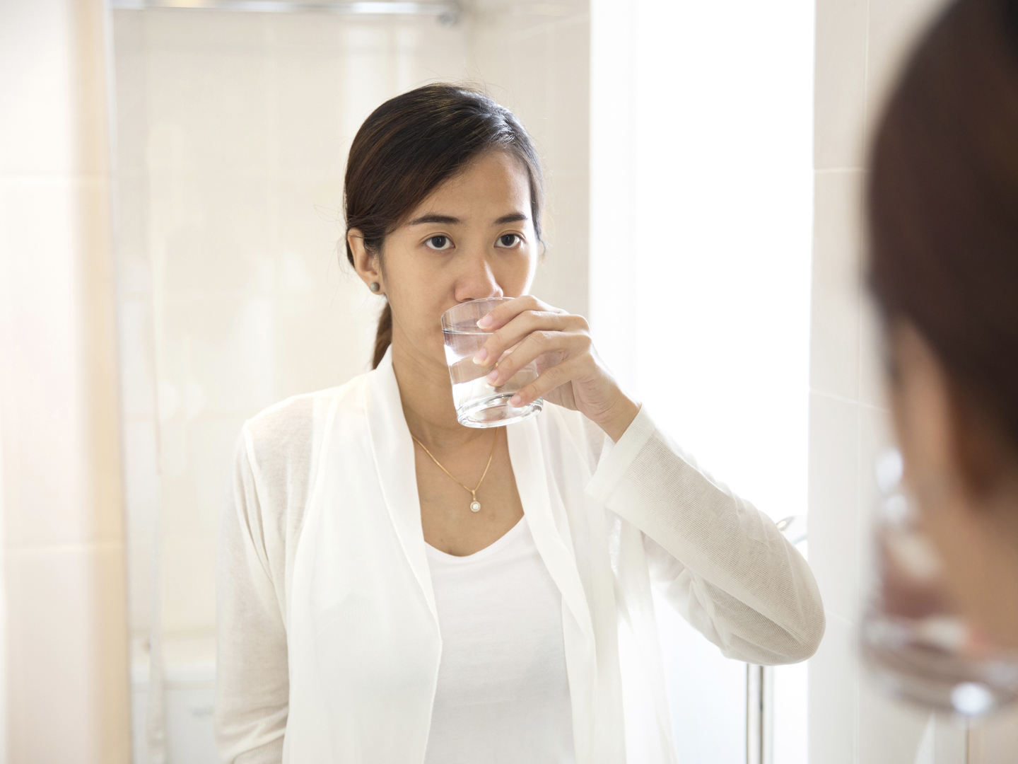 A portrait of an Asian young woman gargle on her mouth after tooth brushing