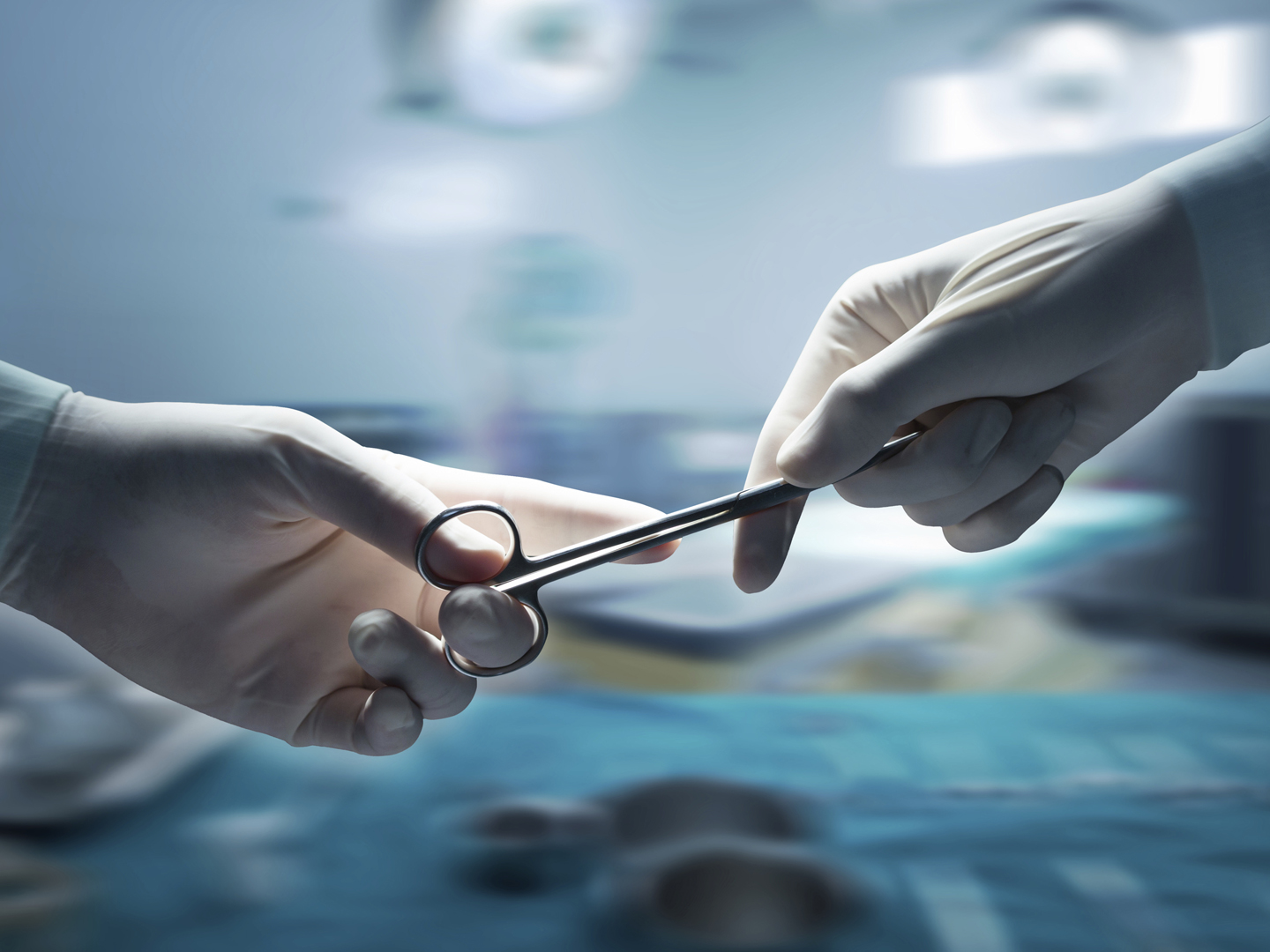 healthcare and medical concept , Close-up of surgeons hands holding surgical scissors and passing surgical equipment , motion blur background.