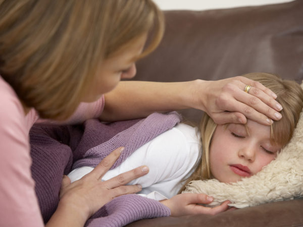 Mother Taking Temperature Of Sick Daughter at home