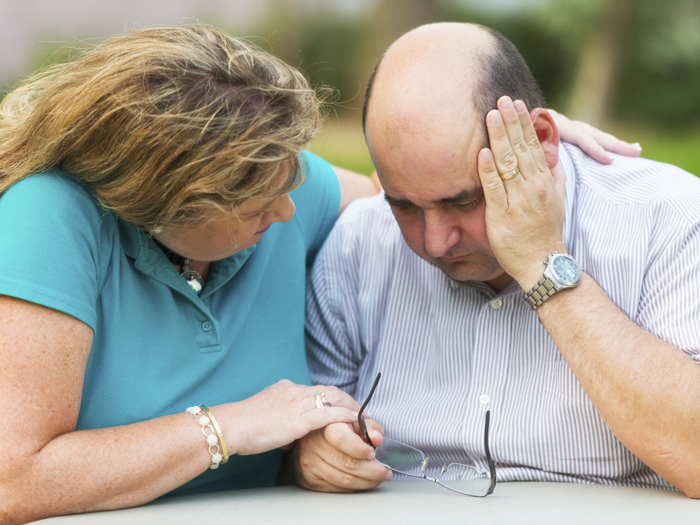 Mature couple sitting, he is feeling really bad