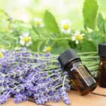 essential oils for aromatherapy treatment with herbal flowers using chamomile, lemon balm, and lavender on the wooden table