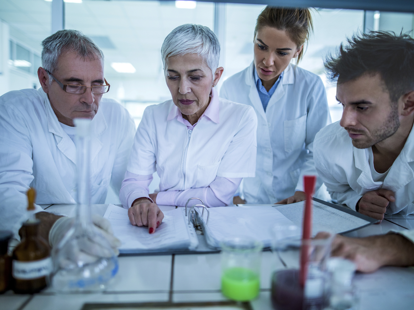 Team of chemists having a meeting in laboratory and working on new scientific researches.