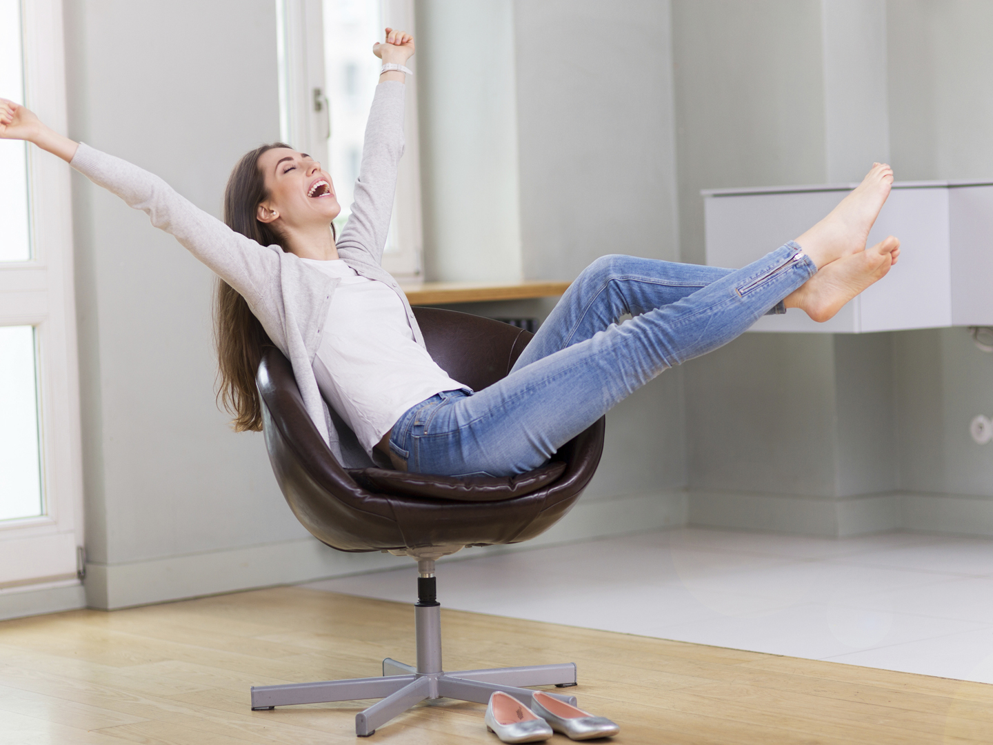 Woman sitting in armchair, arms outstretched