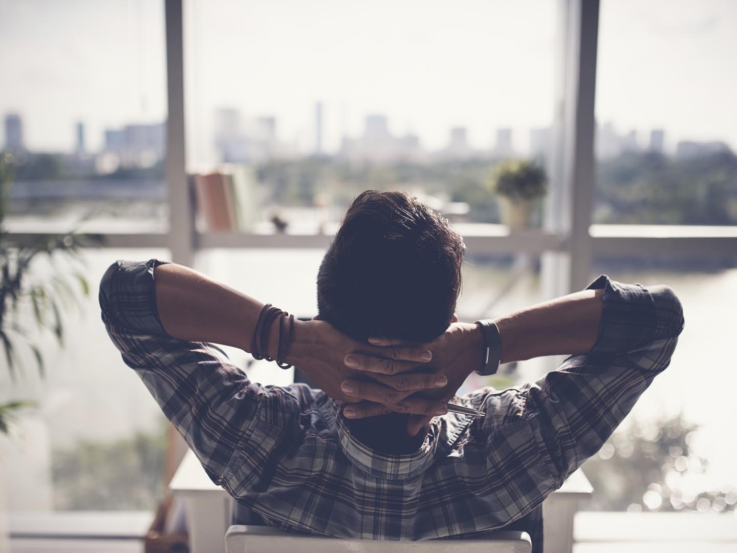 Man relaxing in his chair and enjoying the view from office window