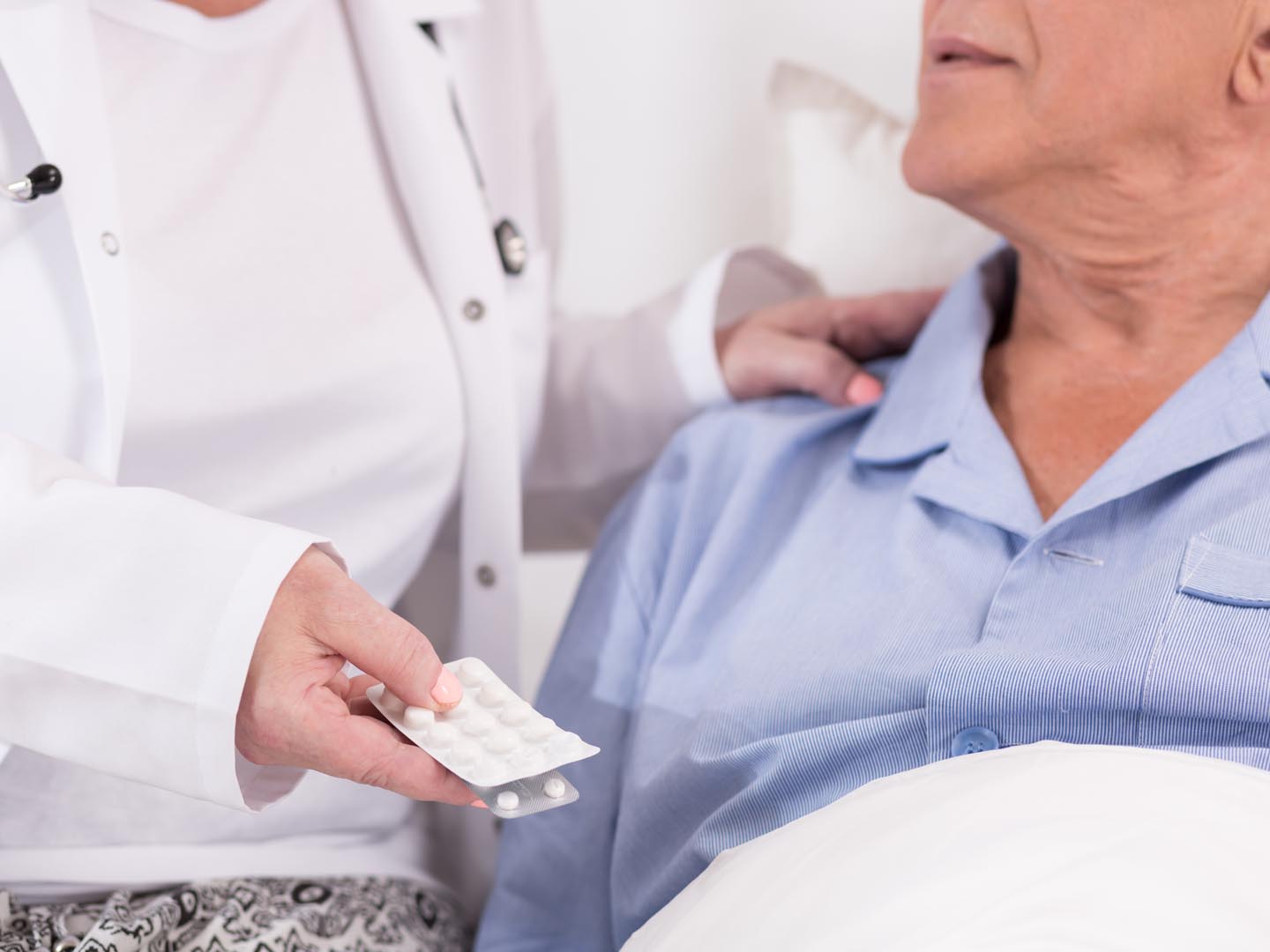 Close up of nurse giving medicines to ill patient