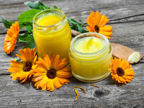 Homemade calendula ointment on wooden table